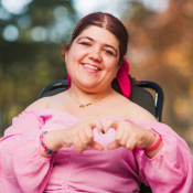 Woman in Pink Dress making the shape of a heart with her hands